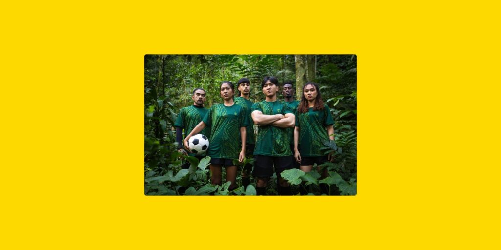 Joueurs de football dans un environnement forestier, illustrant le lien entre sport, sensibilisation environnementale et développement durable.